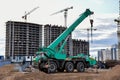 Mobile auto crane at construction site. Work of truck crane on project works. Tower cranes and builders in action Royalty Free Stock Photo