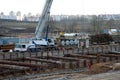 Mobile auto cranes working at construction site. Digging a pit for the building of an underground tunnel of the metro line. Subway