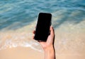 Mobile beach phone with empty screen. Mockup image of black blank desktop screen in hand. Royalty Free Stock Photo