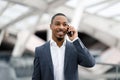 Mobile Call. Portrait Of Young Black Businessman Talking On Cellphone At Airport Royalty Free Stock Photo