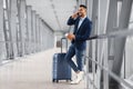Mobile Call. Smiling Young Middle Eastern Businessman Talking On Cellphone In Airport Royalty Free Stock Photo
