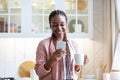 Mobile Communication. Cheerful African Female Using Smartphone And Enjoying Coffee In Kitchen Royalty Free Stock Photo