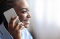 Mobile Communication. Closeup of smiling black woman talking on cellphone, side view Royalty Free Stock Photo