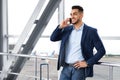 Mobile Communication. Handsome Middle Eastern Man Talking On Cellphone In Airport Royalty Free Stock Photo