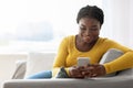 Mobile Communication. Happy African American Woman Reading Messages On Smartphone At Home