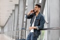 Mobile Communication. Smiling Young Arab Guy Talking On Cellphone At Airport Royalty Free Stock Photo