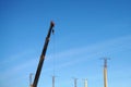 Mobile construction crane and piles on a blue sky background. Building new apartment concept Royalty Free Stock Photo