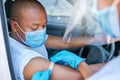 Mobile covid vaccine service outdoors for a patient driving in a car. A healthcare professional applying a plaster on a