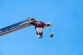 Mobile crane boom with hook hanging by wire cable background blue sky Royalty Free Stock Photo