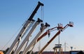 Mobile crane booms and work aerial platforms lined up in an industrial development area Royalty Free Stock Photo