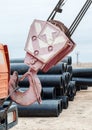 Construction crane hook with some industrial buildings on the ba