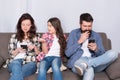 Mobile device affecting relationship. Unhappy kid complain at parents using phones. Smartphone addicts. Family Royalty Free Stock Photo