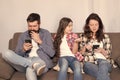 Mobile device affecting relationship. Unhappy kid complain at parents using phones. Smartphone addicts. Family Royalty Free Stock Photo