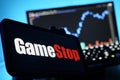 Gamestop Logo On Mobile And Computer Screens With Stock Chart Background Royalty Free Stock Photo