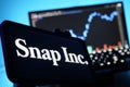 Snap Snapchat Logo On Mobile And Computer Screens With Stock Chart Background Royalty Free Stock Photo