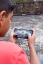 Mobile game played on android device feature phone or smart phone. Cropped hand Teenage gamer boy playing video games on smart Royalty Free Stock Photo