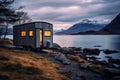 Mobile House stands against lake and mountains view. tiny house embraces the adventurous.