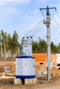 A mobile live transformer booth stands near high voltage poles on a construction site Royalty Free Stock Photo