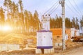 A mobile live transformer booth stands near high voltage poles on a construction site at sunset Royalty Free Stock Photo