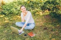 Mobile Office. Freelance business concept. Young woman sitting on green grass lawn in city park working on laptop pc computer. Royalty Free Stock Photo