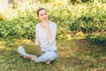 Mobile Office. Freelance business concept. Young woman sitting on green grass lawn in city park working on laptop pc computer. Royalty Free Stock Photo