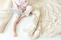 Mobile Office at home. Young woman in pajamas sitting on bed at home working using on laptop pc computer. Lifestyle girl studying Royalty Free Stock Photo