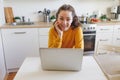 Mobile Office at home. Young woman sitting in kitchen at home working using on laptop computer. Lifestyle girl studying or working Royalty Free Stock Photo