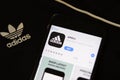 Mobile phone with Adidas app icon on screen and adidas logo on background. Los Angeles, California, USA - 30 November 2019,