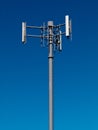 Mobile phone antennas on metal tower on blue sky