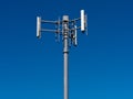 Mobile phone antennas on metal tower on blue sky
