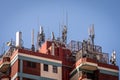 Mobile phone base station antennas placed over the rooftops of a building Royalty Free Stock Photo