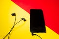 Mobile phone with black headset on a colorful background Royalty Free Stock Photo