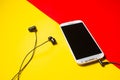 Mobile phone with black headset on a colorful background Royalty Free Stock Photo