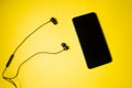 Mobile phone with black headset on a colorful background Royalty Free Stock Photo