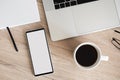 Mobile phone with blank empty white mockup screen, home office scene. Workplace, laptop computer, smartphone on office desk Royalty Free Stock Photo