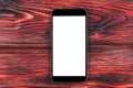 Mobile phone with blank screen mock up. isolated white screen on red wooden table background. Smartphone on wooden table. Smartpho Royalty Free Stock Photo