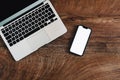 Mobile phone with blank white mockup touchscreen and laptop computer on office desk, top view Royalty Free Stock Photo