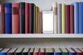 Mobile phone in bookshelf with sorted books