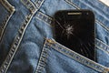 mobile phone broken cracked touch screen in the back pocket of jeans denim trousers in accident and careless concept Royalty Free Stock Photo