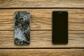 Mobile phone with broken touchscreen on wooden background