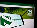 Mobile phone with business logo of South African bank Nedbank Group Limited on screen in front of website.