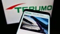 Mobile phone with business webpage of Japanese medical equipment company Terumo Corp. on screen in front of logo.