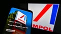 Mobile phone with business website of Australian oil, fuel and gas company Ampol Limited on screen in front of logo.