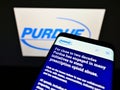 Mobile phone with business website of US pharmaceuticals company Purdue Pharma L.P. on screen in front of logo.