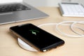 Mobile phone charging with wireless pad on table, closeup Royalty Free Stock Photo