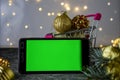 Mobile phone with chromakey on the background of Christmas decorations. Bokeh. Chromakey. Space for text