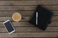 Mobile phone, coffee, pen and organizer on wooden plank Royalty Free Stock Photo