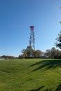 Mobile phone communication antenna tower with the blue sky, Telecommunication tower in a green grass field Royalty Free Stock Photo