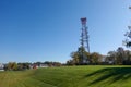 Mobile phone communication antenna tower with the blue sky, Telecommunication tower in a green grass field Royalty Free Stock Photo