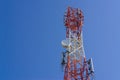 Mobile phone communication antenna tower with satellite dish on blue sky background Royalty Free Stock Photo